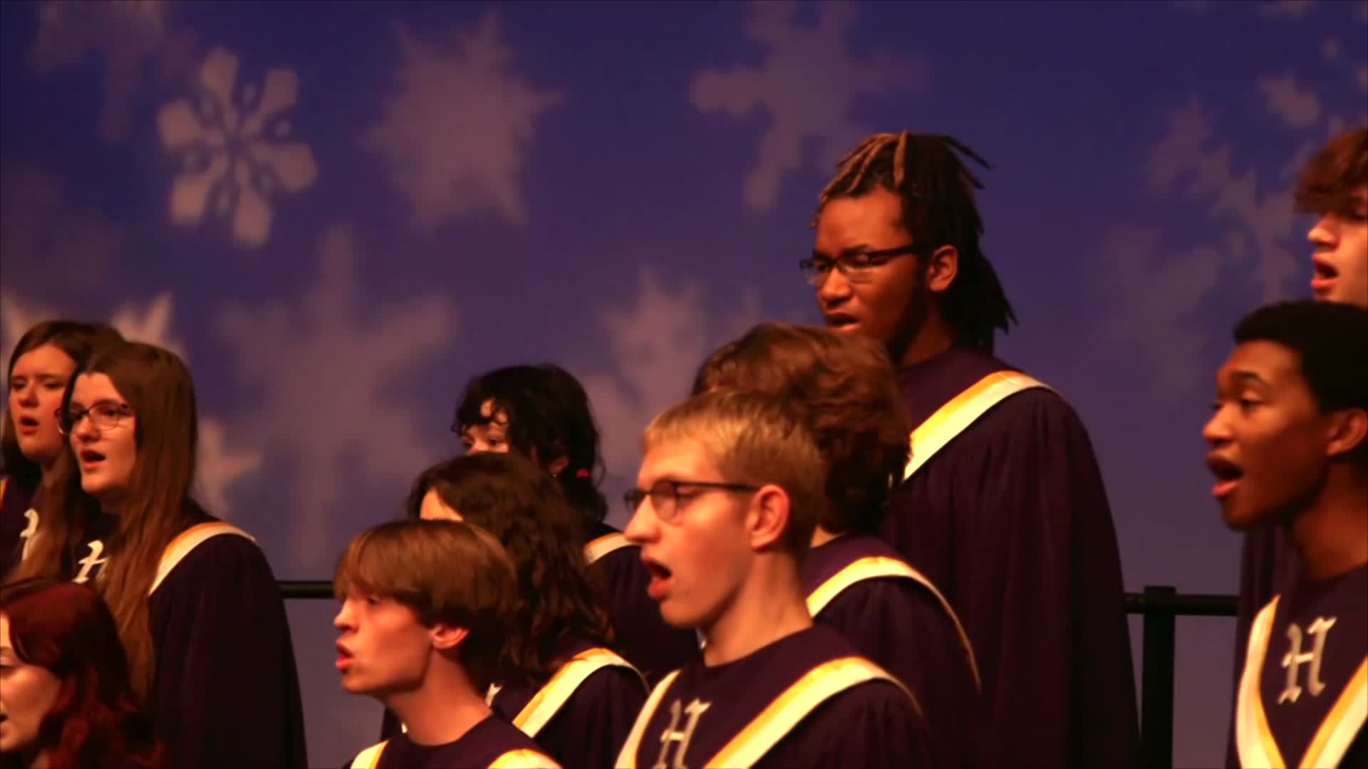 Hickman students in choir robes singing.