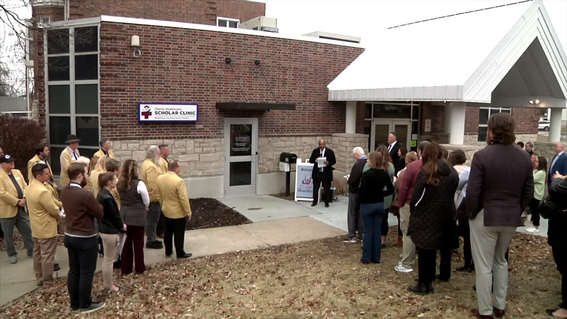 A group of people gather in front of the Scholar Clinic for its dedication. 