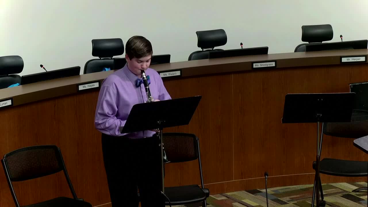 West Middle School student plays the clarinet in the school board room.
