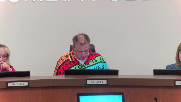 Board of Education President, John Lyman sits at the board dais.